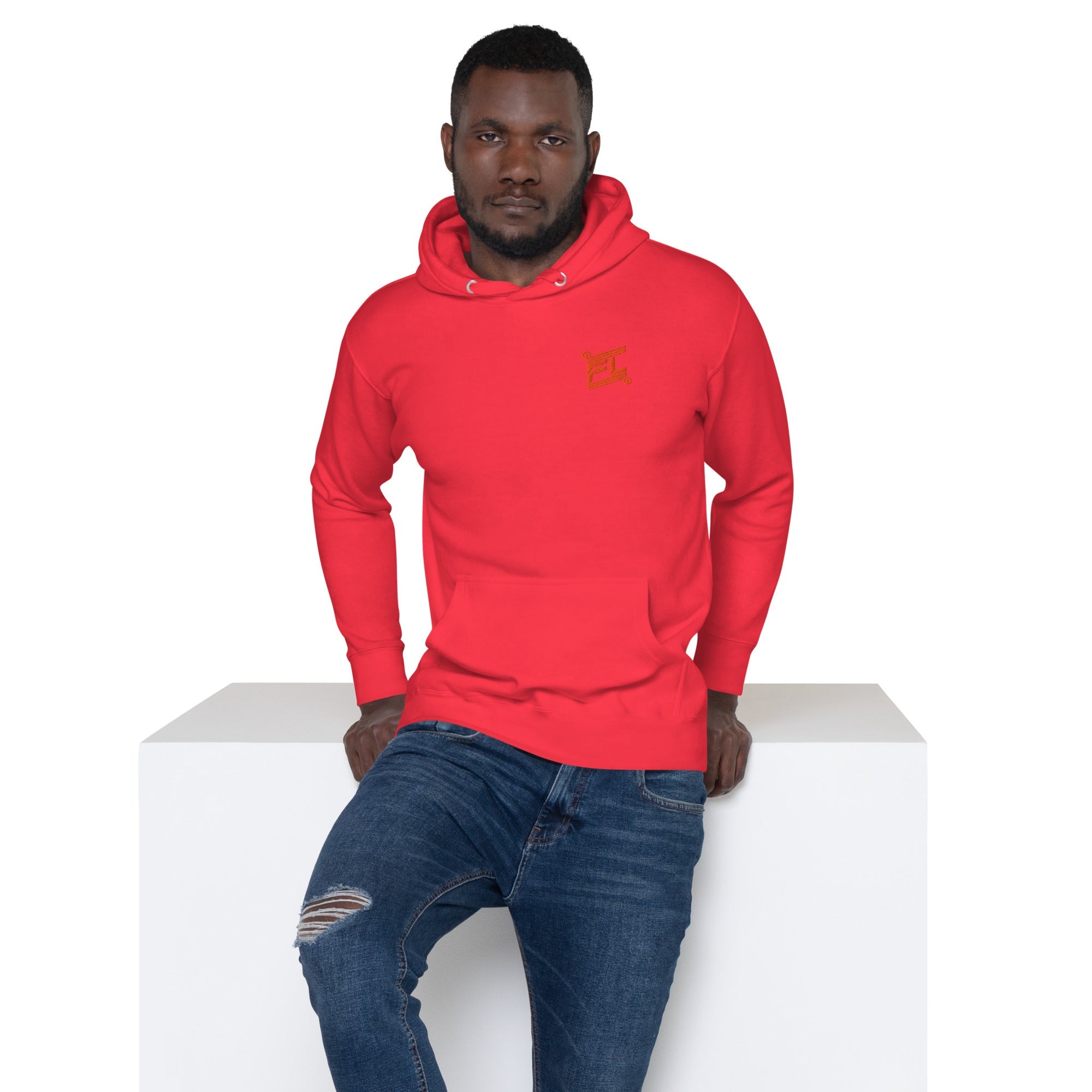 Homme portant le Hoodie Ignite rouge de la marque FL-Fit avec logo brodé, assis sur un bloc blanc.